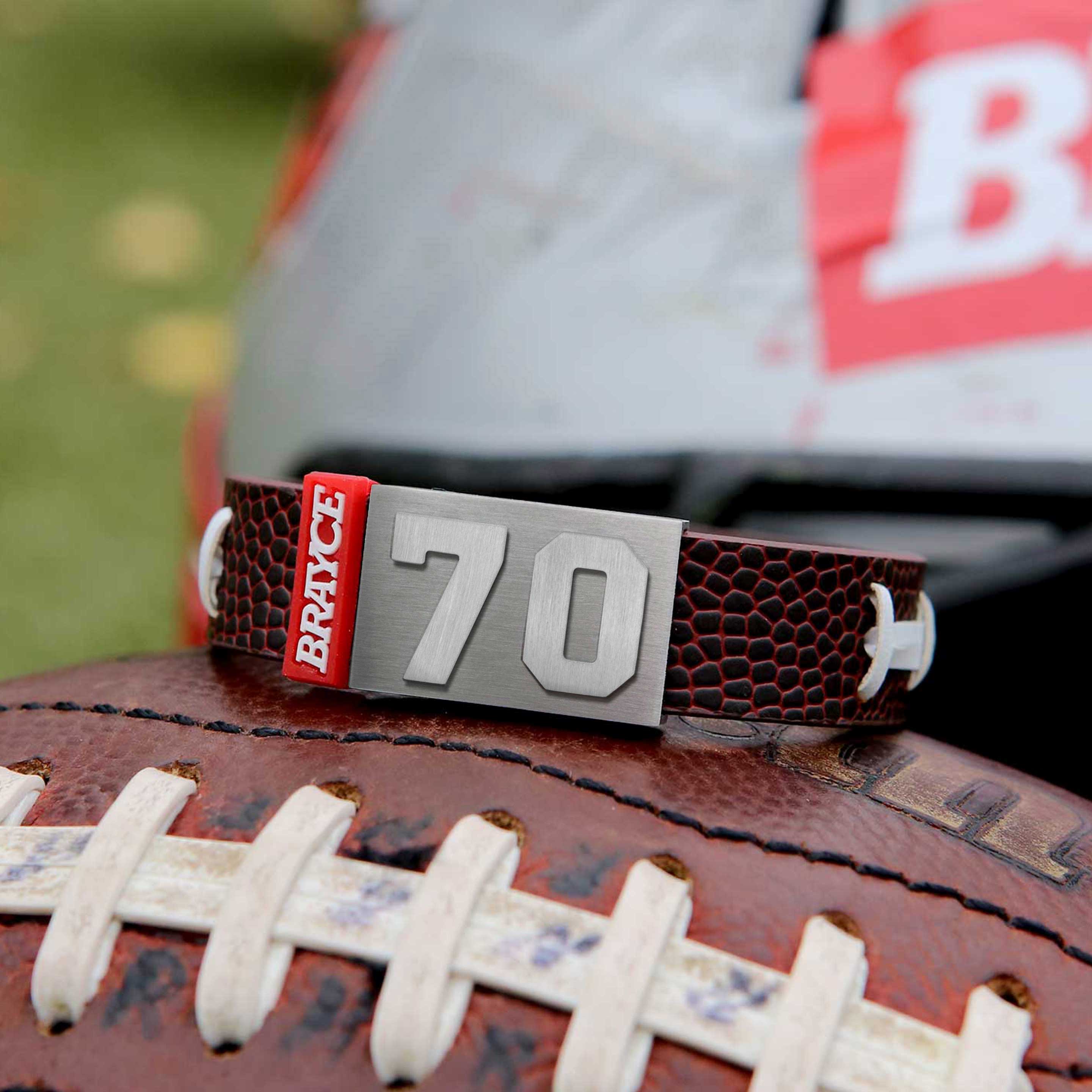 American Football Armband mit Trikotnummer 70 auf einem Football liegend